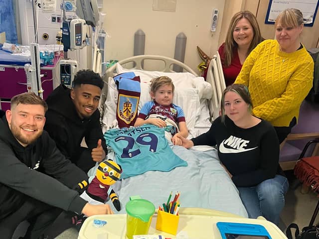 Charlie Paine receives a visit from Burnley player Ian Maatsen at the Royal Manchester Children's Hospital, surrounded by his dad Kieran, mum Megan and his grandma Elizabeth McCabe and nan Jane Foster