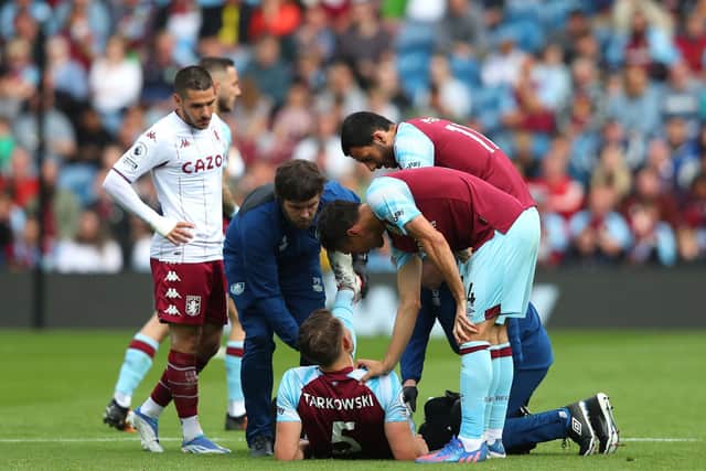 BURNLEY, ENGLAND - MAY 07: James Tarkowski of Burnley receives medical treatment during the Premier League match between Burnley and Aston Villa at Turf Moor on May 07, 2022 in Burnley, England. (Photo by Alex Livesey/Getty Images)