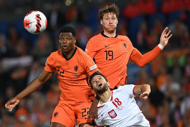 Netherlands' defender Denzel Dumfries (L), Netherlands' striker Wout Weghorst (C) fight for the ball with Poland's defender Bartosz Bereszynski (R) during the UEFA Nations League, League A Group 4 football match between Netherlands and Poland at the Feyenoord "De Kuip" stadium in Rotterdam on June 11, 2022. (Photo by JOHN THYS / various sources / AFP) (Photo by JOHN THYS/AFP via Getty Images)