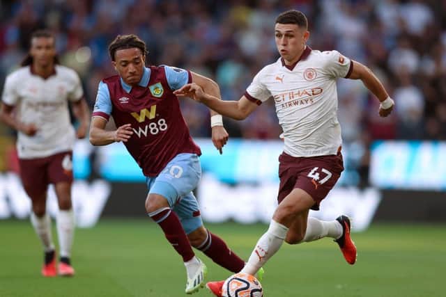 BURNLEY, ENGLAND - AUGUST 11: Phil Foden of Manchester City runs with the ball whilst under pressure from Luca Koleosho of Burnley during the Premier League match between Burnley FC and Manchester City at Turf Moor on August 11, 2023 in Burnley, England. (Photo by Nathan Stirk/Getty Images)