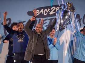 Manchester City's Spanish manager Pep Guardiola (C), Manchester City assistant coach Mikel Arteta (R) and Manchester City's Belgian defender Vincent Kompany (L) show the Premier League trophy to supporters outside the Etihad Stadium in Manchester, northern England on May 12, 2019. (Photo by OLI SCARFF / AFP)