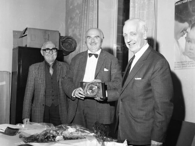 Mr Pickup (centre) takes time out to receive the clock presented to him to mark 13 years as local Liberal chairman. On the left is Mr George Gregory and on the right is Alderman Sutcliffe.