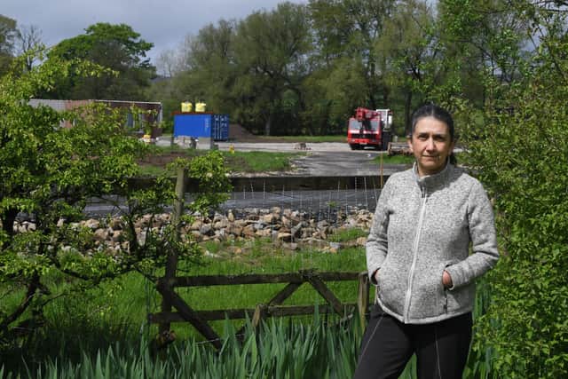 Sheila Cromie who is protesting about applications to remove and alter some of the planning conditions at the Ribchester snail farm and holiday lodge development site which is pictured in the background of the photo      Photo Neil Cross