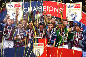 BURNLEY, ENGLAND - MAY 08: Jack Cork and Josh Brownhill of Burnley lift the Sky Bet Championship trophy with teammates after victory against Cardiff City during the Sky Bet Championship between Burnley and Cardiff City at Turf Moor on May 08, 2023 in Burnley, England. (Photo by Gareth Copley/Getty Images)