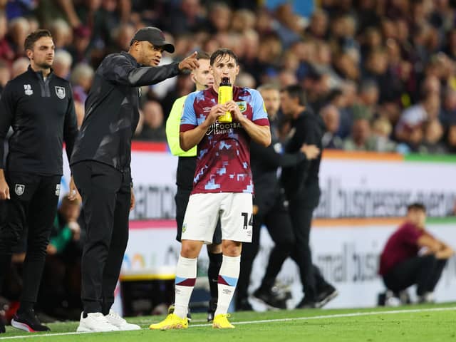 BURNLEY, ENGLAND - AUGUST 16: Vincent Kompany, Manager of Burnley interacts with Connor Roberts of Burnley   during the Sky Bet Championship between Burnley and Hull City at Turf Moor on August 16, 2022 in Burnley, England. (Photo by Clive Brunskill/Getty Images)