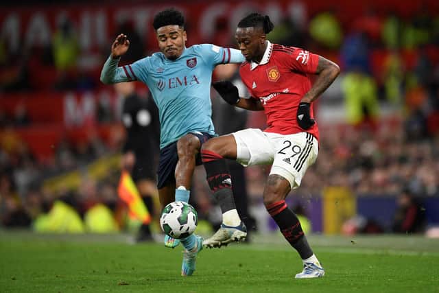 Burnley's Dutch defender Ian Maatsen (L) fights for the ball with Manchester United's English defender Aaron Wan-Bissaka during the English League Cup fourth round football match between Manchester United and Burnley, at Old Trafford, in Manchester, on December 21, 2022.