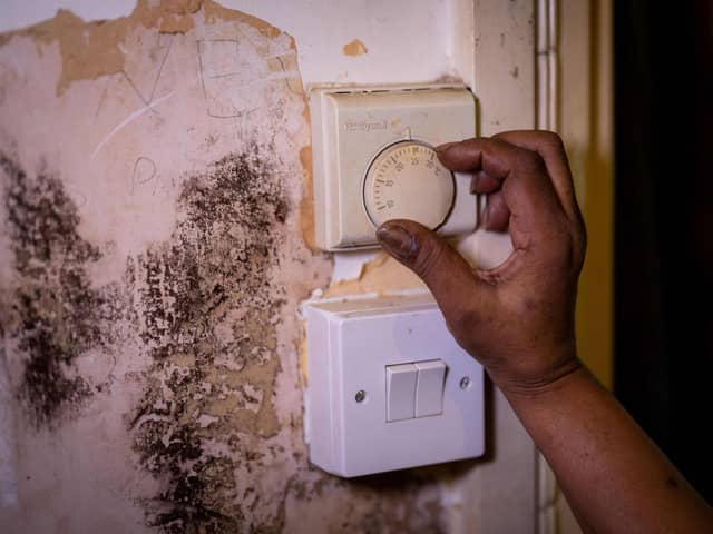 Woman adjusts a thermostat at her home as she limits her use of heating to keep up with her increasing energy bills. (Photo by TOLGA AKMEN/AFP via Getty Images)