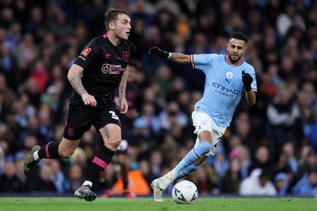 MANCHESTER, ENGLAND - MARCH 18: Jordan Beyer of Burnley runs with the ball while under pressure from Riyad Mahrez of Manchester City during the Emirates FA Cup Quarter Final match between Manchester City and Burnley at Etihad Stadium on March 18, 2023 in Manchester, England. (Photo by Clive Brunskill/Getty Images)