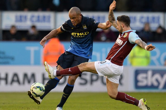 Manchester City's Belgian defender Vincent Kompany (L) is closed down by Burnley's English striker Danny Ings during the English Premier League football match between Burnley and Manchester City at Turf Moor in Burnley, north west England, on March 14, 2015. AFP PHOTO / OLI SCARFF