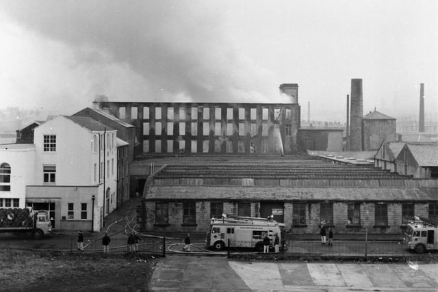 Britannia Mill, Lune Street, Padiham. March 11, 1971.

The morning after - a rooftop picture of the gutted mill, taken by Express chief photographer, Jerry Bradley, showing firemen using hoses to keep the blaze under control.

Firemen continued damping down work last night at the Padiham mill which was gutted by fire in the early hours of yesterday morning, 11th March 1971. A spokesman for Lancashire County fire Brigade said yesterday afternoon: "It is difficult to say how long we will be needed, but there is no doubt that damping down will take another 12 hours." In charge of the 150 firemen who tackled the fire was the county's chief Fire Officer, Mr P. Darby.

Most of the 70 workers employed at the firm, Padiham Cotton and Cotton Waste Co. Ltd, Britannia Mill, were sent home yesterday morning, and the rest helped with salvaging operations as firemen stayed at the scene in case the fire flared up again. A police constable on duty spotted the blaze about 1.20 a.m., and 25 fire appliances were brought from all over Lancashire, including Manchester and the Fylde Coast. The Divisional Fire Officer, Mr F. J. Kelly said: "We found it a hazardous and dangerous job and, initially, there was so much smoke that the only means of entry was by wearing breathing apparatus". The premises of Padiham Paints is next door to the gutted mill, and one of the major problems for firemen was in keeping the blaze away from the building.