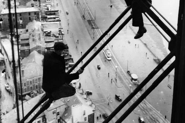 Men 500ft up Blackpool Tower where repairs were being carried out. How did they actually get up there? The promenade and beach are clearly visible below