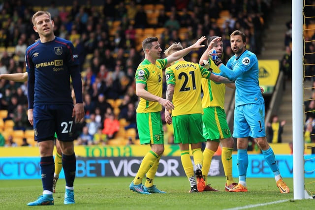 NORWICH, ENGLAND - APRIL 10: Tim Krul of Norwich City is congratulated by Grant Hanley and Brandon Williams during the Premier League match between Norwich City and Burnley at Carrow Road on April 10, 2022 in Norwich, England. (Photo by Stephen Pond/Getty Images)
