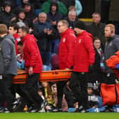 BURNLEY, ENGLAND - FEBRUARY 17: Aaron Ramsey of Burnley receives medical treatment and is stretchered off during the Premier League match between Burnley FC and Arsenal FC at Turf Moor on February 17, 2024 in Burnley, England. (Photo by Marc Atkins/Getty Images)