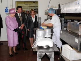 Queen Elizabeth II pictured with brother and sister Bill Riding and Tilly Carefoot watching the cheese making process during a royal visit to Singletons dairy in June 2008.
