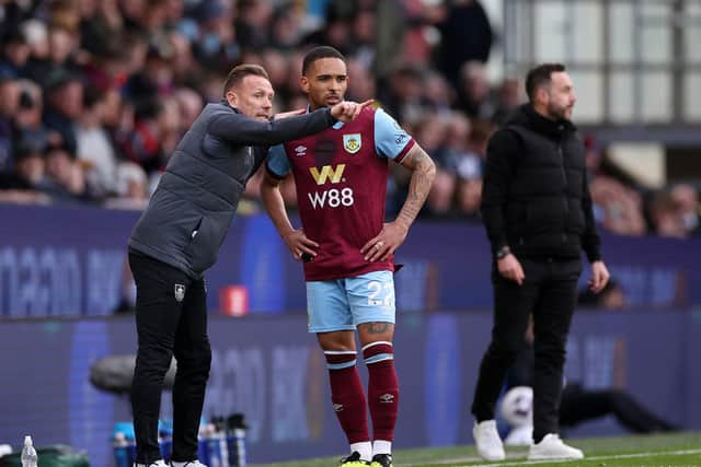BURNLEY, ENGLAND - APRIL 13: Craig Bellamy, Assistant Manager of Burnley, speaks to Vitinho of Burnley during the Premier League match between Burnley FC and Brighton & Hove Albion at Turf Moor on April 13, 2024 in Burnley, England. (Photo by Lewis Storey/Getty Images)