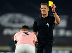 English referee Robert Jones shows a yellow card to Sheffield United's Irish defender Enda Stevens. (Photo by JASON CAIRNDUFF/POOL/AFP via Getty Images)