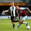 BURNLEY, ENGLAND - MAY 22: Dwight McNeil of Burnley on the ball whilst under pressure from Matt Targett of Newcastle United during the Premier League match between Burnley and Newcastle United at Turf Moor on May 22, 2022 in Burnley, England. (Photo by Jan Kruger/Getty Images)