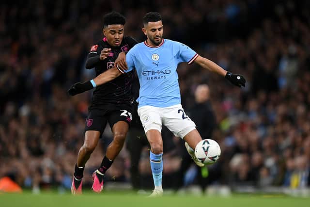 MANCHESTER, ENGLAND - MARCH 18: Riyad Mahrez of Manchester City is challenged by Ian Maatsen of Burnley during the Emirates FA Cup Quarter Final match between Manchester City and Burnley at Etihad Stadium on March 18, 2023 in Manchester, England. (Photo by Michael Regan/Getty Images)