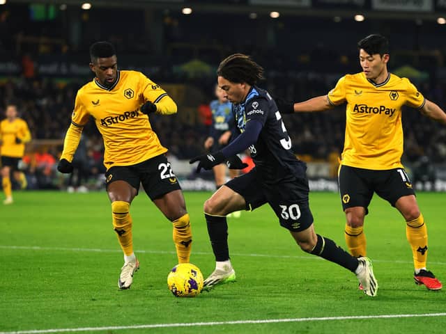 WOLVERHAMPTON, ENGLAND - DECEMBER 05: Luca Koleosho of Burnley controls the ball whilst under pressure from Nelson Semedo and Hwang Hee-Chan of Wolverhampton Wanderers during the Premier League match between Wolverhampton Wanderers and Burnley FC at Molineux on December 05, 2023 in Wolverhampton, England. (Photo by David Rogers/Getty Images)