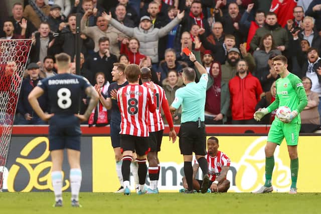 BRENTFORD, ENGLAND - MARCH 12: Nathan Collins of Burnley is shown a red card by match referee Paul Tierney for a tackle on Ivan Toney of Brentford during the Premier League match between Brentford and Burnley at Brentford Community Stadium on March 12, 2022 in Brentford, England.