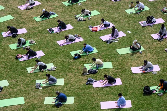 People taking part in a yoga class. (Photo by Anthony WALLACE / AFP) (Photo by ANTHONY WALLACE/AFP via Getty Images)