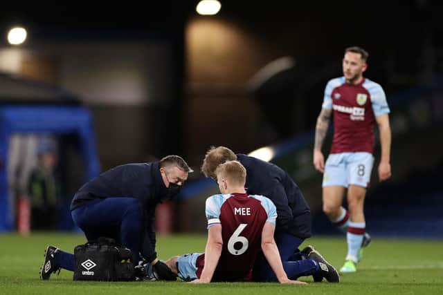 BURNLEY, ENGLAND - MARCH 01: Ben Mee of Burnley receives medical treatment before being substituted during the Premier League match between Burnley and Leicester City at Turf Moor on March 01, 2022 in Burnley, England.