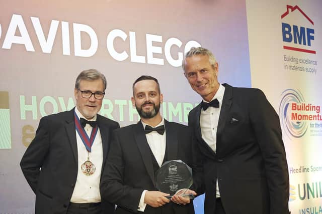 David Clegg receives the Best Performing Student 2023 Award from Richard Hill, Master of the Worshipful Company of Builders Merchants (left) and awards host, Mark Foster