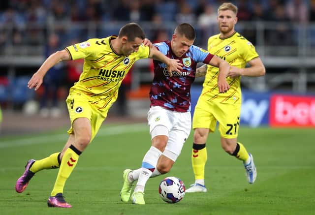BURNLEY, ENGLAND - AUGUST 30: Johann Berg Gudmundsson of Burnley holds off Murray Wallace of Millwall during the Sky Bet Championship between Burnley and Millwall at Turf Moor on August 30, 2022 in Burnley, England. (Photo by Alex Livesey/Getty Images)