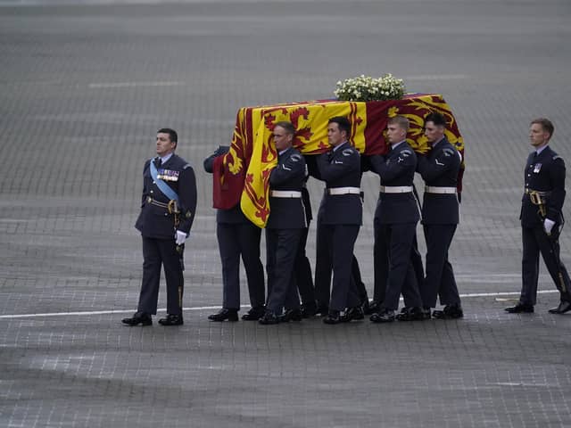 Pallbearers from the Queen's Colour Squadron (63 Squadron RAF Regiment) transfer the coffin of Queen Elizabeth II to the Royal Hearse having removed it from the C-17 at the Royal Air Force Northolt airbase on September 13, 2022.