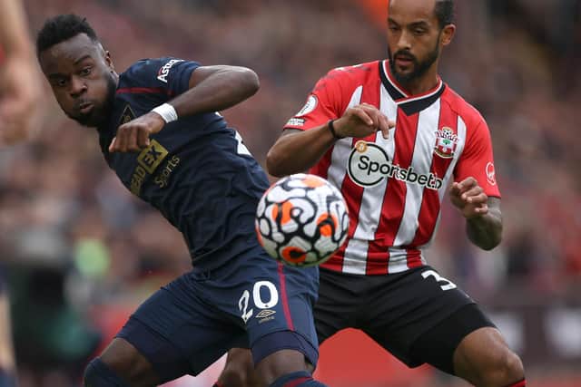 SOUTHAMPTON, ENGLAND - OCTOBER 23: Theo Walcott of Southampton challenges Maxwel Cornet of Burnley during the Premier League match between Southampton and Burnley at St Mary's Stadium on October 23, 2021 in Southampton, England. (Photo by Eddie Keogh/Getty Images)