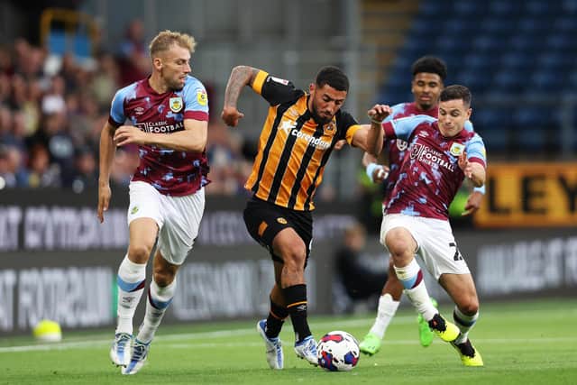 BURNLEY, ENGLAND - AUGUST 16: Allahyar Sayyadmanesh of Hull City is challenged by Josh Cullen and Charlie Taylor of Burnley  during the Sky Bet Championship between Burnley and Hull City at Turf Moor on August 16, 2022 in Burnley, England. (Photo by Clive Brunskill/Getty Images)