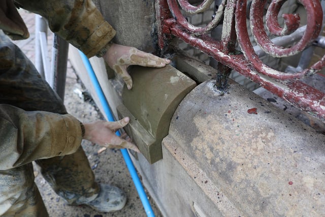 A coping stone being inserted at ground level
