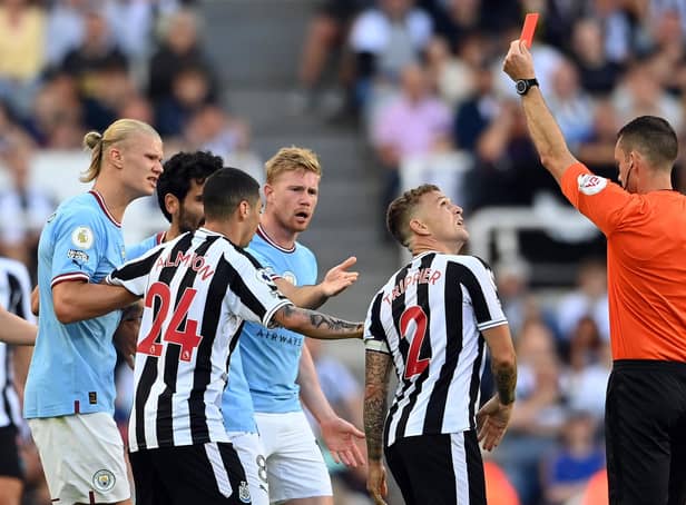 NEWCASTLE UPON TYNE, ENGLAND - AUGUST 21: Kieran Trippier of Newcastle United is shown a red card by referee Jarred Gillett which is later overturned to a yellow card  during the Premier League match between Newcastle United and Manchester City at St. James Park on August 21, 2022 in Newcastle upon Tyne, England. (Photo by Stu Forster/Getty Images)
