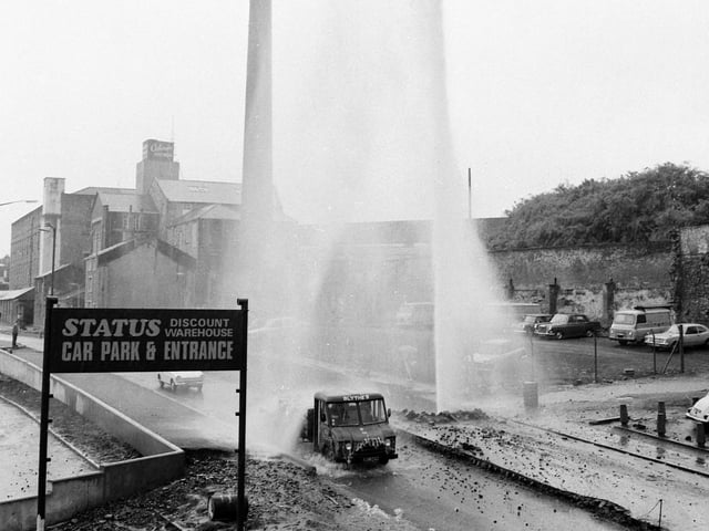 Finsley Gate, Burnley. June 22, 1973.
A major disaster was averted after a 60-foot high fountain of water shot into the air when an excavator snapped off the valve to the mains under Finsley Gate this week. The roadway became a torrent, Calder Water Board engineers struggled to turn off the supply. Within 15 minutes the 18-inch trunk main water pipe was under control, thanks to a lucky coincidence. "It just so happened that we had a spare valve in stock. We aren't always prepared for a major burst like this" said a water board spokesman. He described the burst, which cut off water supplies in the immediate area for more than two hours, as very serious. "If we hadn't had the spare in stock, it could have taken months to repair the main" he said.
Water burst from the mains when the driver of the excavator accidentally pulled off the concealed cap to the valve. But no one was near the pipe when it burst and no one was injured. But as the fountain soared into the air, some cars continued to travel along the road, despite falling rubble and soil.