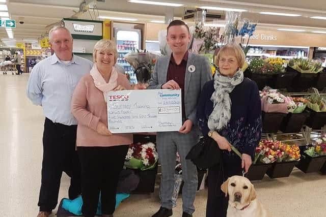 Burnley Talking Newspaper volunteers Alan and Marjorie Dunderdale with Ann Kay and guide dog Dixie receive a cheque from Tesco, one of the organisation's many supporters.
