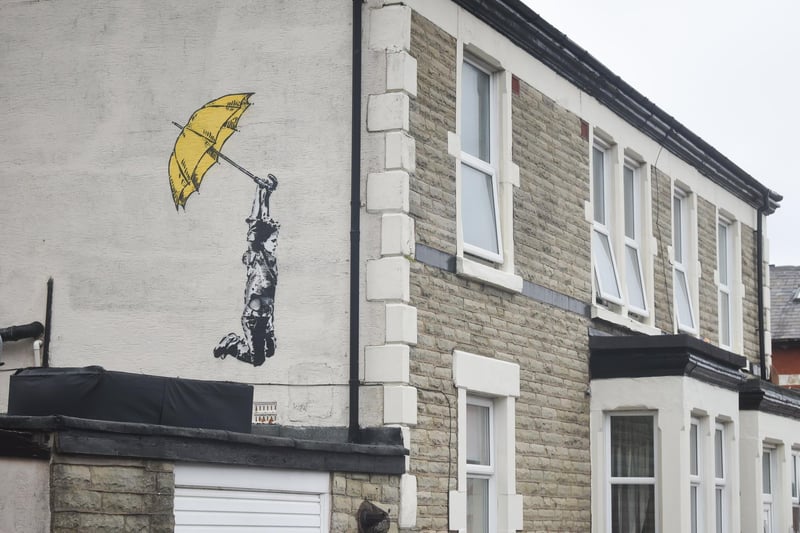 A mural in the style of Banksy appeared on house in Milbourne Street in Blackpool. The distinctive work of art was discovered  on the side of a terraced home in Milbourne Street. It depicted a boy holding onto a yellow umbrella in the familiar style of the famous yet elusive artist whose identity remains a mystery. The artwork was not confirmed as an authentic Banksy