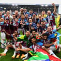 BURNLEY, ENGLAND - MAY 08: Players of Burnley celebrate with the Sky Bet Championship trophy as they celebrate promotion to the Premier League after defeating Cardiff City during the Sky Bet Championship between Burnley and Cardiff City at Turf Moor on May 08, 2023 in Burnley, England. (Photo by Gareth Copley/Getty Images)