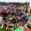 BURNLEY, ENGLAND - MAY 08: Players of Burnley celebrate with the Sky Bet Championship trophy as they celebrate promotion to the Premier League after defeating Cardiff City during the Sky Bet Championship between Burnley and Cardiff City at Turf Moor on May 08, 2023 in Burnley, England. (Photo by Gareth Copley/Getty Images)