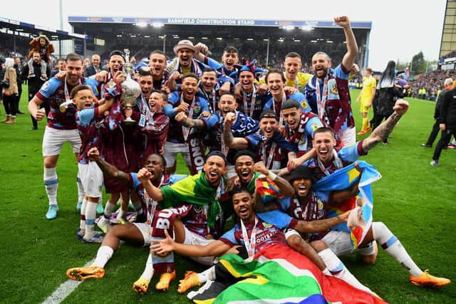 BURNLEY, ENGLAND - MAY 08: Players of Burnley celebrate with the Sky Bet Championship trophy as they celebrate promotion to the Premier League after defeating Cardiff City during the Sky Bet Championship between Burnley and Cardiff City at Turf Moor on May 08, 2023 in Burnley, England. (Photo by Gareth Copley/Getty Images)