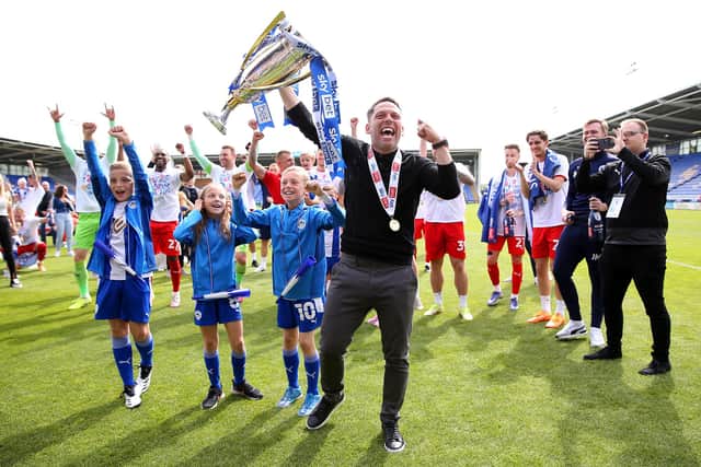 SHREWSBURY, ENGLAND - APRIL 30: Leam Richardson, Manager of Wigan Athletic celebrates with the League One trophy after their sides victory and promotion to the Championship during the Sky Bet League One match between Shrewsbury Town and Wigan Athletic at Montgomery Waters Meadow on April 30, 2022 in Shrewsbury, England. (Photo by Charlotte Tattersall/Getty Images)