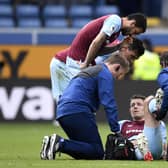Burnley's English defender James Tarkowski is treated by medical staff during the English Premier League football match between Burnley and Aston Villa at Turf Moor in Burnley, north west England on May 7, 2022. - RESTRICTED TO EDITORIAL USE. No use with unauthorized audio, video, data, fixture lists, club/league logos or 'live' services. Online in-match use limited to 120 images. An additional 40 images may be used in extra time. No video emulation. Social media in-match use limited to 120 images. An additional 40 images may be used in extra time. No use in betting publications, games or single club/league/player publications. (Photo by Oli SCARFF / AFP) / RESTRICTED TO EDITORIAL USE. No use with unauthorized audio, video, data, fixture lists, club/league logos or 'live' services. Online in-match use limited to 120 images. An additional 40 images may be used in extra time. No video emulation. Social media in-match use limited to 120 images. An additional 40 images may be used in extra time. No use in betting publications, games or single club/league/player publications. / RESTRICTED TO EDITORIAL USE. No use with unauthorized audio, video, data, fixture lists, club/league logos or 'live' services. Online in-match use limited to 120 images. An additional 40 images may be used in extra time. No video emulation. Social media in-match use limited to 120 images. An additional 40 images may be used in extra time. No use in betting publications, games or single club/league/player publications. (Photo by OLI SCARFF/AFP via Getty Images)