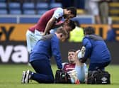Burnley's English defender James Tarkowski is treated by medical staff during the English Premier League football match between Burnley and Aston Villa at Turf Moor in Burnley, north west England on May 7, 2022. - RESTRICTED TO EDITORIAL USE. No use with unauthorized audio, video, data, fixture lists, club/league logos or 'live' services. Online in-match use limited to 120 images. An additional 40 images may be used in extra time. No video emulation. Social media in-match use limited to 120 images. An additional 40 images may be used in extra time. No use in betting publications, games or single club/league/player publications. (Photo by Oli SCARFF / AFP) / RESTRICTED TO EDITORIAL USE. No use with unauthorized audio, video, data, fixture lists, club/league logos or 'live' services. Online in-match use limited to 120 images. An additional 40 images may be used in extra time. No video emulation. Social media in-match use limited to 120 images. An additional 40 images may be used in extra time. No use in betting publications, games or single club/league/player publications. / RESTRICTED TO EDITORIAL USE. No use with unauthorized audio, video, data, fixture lists, club/league logos or 'live' services. Online in-match use limited to 120 images. An additional 40 images may be used in extra time. No video emulation. Social media in-match use limited to 120 images. An additional 40 images may be used in extra time. No use in betting publications, games or single club/league/player publications. (Photo by OLI SCARFF/AFP via Getty Images)