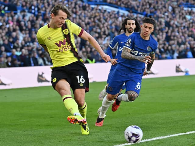 Burnley's Norwegian midfielder #16 Sander Berge (L) crosses the ball during the English Premier League football match between Chelsea and Burnley at Stamford Bridge in London on March 30, 2024. (Photo by Glyn KIRK / AFP) /