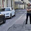County Coun. Usman Arif and Burnley shopkeeper Mubashar Lone in front of potholes on a Burnley street