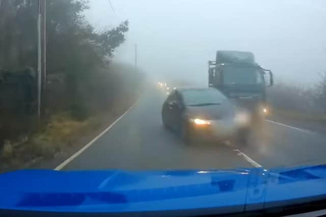 This driver was caught on dash cam overtaking a lorry in thick fog and narrowly avoiding a head-on crash with an oncoming car. Pic credit: Lancashire Police