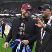 BURNLEY, ENGLAND - MAY 08: Vincent Kompany, Manager of Burnley speaks with NFL legend and Burnley FC stakeholder JJ Watt after defeating Cardiff City during the Sky Bet Championship between Burnley and Cardiff City at Turf Moor on May 08, 2023 in Burnley, England. (Photo by Gareth Copley/Getty Images)