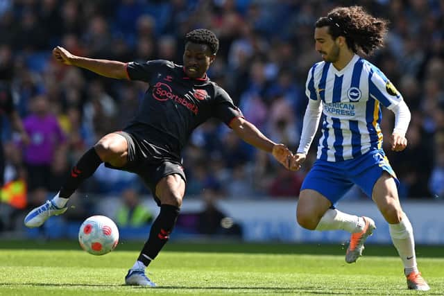 Southampton's English midfielder Nathan Tella (L) vies with Brighton's Spanish defender Marc Cucurella (C) during the English Premier League football match between Brighton and Hove Albion and Southampton at the American Express Community Stadium in Brighton, southern England on April 24, 2022. - RESTRICTED TO EDITORIAL USE. No use with unauthorized audio, video, data, fixture lists, club/league logos or 'live' services. Online in-match use limited to 120 images. An additional 40 images may be used in extra time. No video emulation. Social media in-match use limited to 120 images. An additional 40 images may be used in extra time. No use in betting publications, games or single club/league/player publications. (Photo by Glyn KIRK / AFP) / RESTRICTED TO EDITORIAL USE. No use with unauthorized audio, video, data, fixture lists, club/league logos or 'live' services. Online in-match use limited to 120 images. An additional 40 images may be used in extra time. No video emulation. Social media in-match use limited to 120 images. An additional 40 images may be used in extra time. No use in betting publications, games or single club/league/player publications. / RESTRICTED TO EDITORIAL USE. No use with unauthorized audio, video, data, fixture lists, club/league logos or 'live' services. Online in-match use limited to 120 images. An additional 40 images may be used in extra time. No video emulation. Social media in-match use limited to 120 images. An additional 40 images may be used in extra time. No use in betting publications, games or single club/league/player publications. (Photo by GLYN KIRK/AFP via Getty Images)