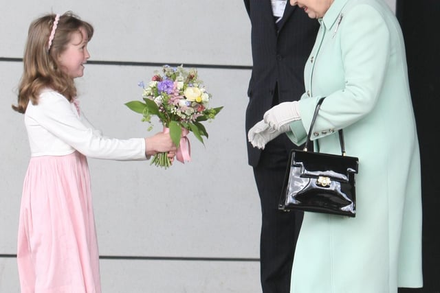 The Queen is presented with a bouquet from Alexandra Brown (6) as she leaves Burnley College.