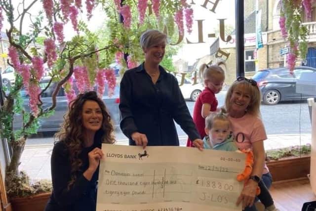 J Lo's owners Josey Packer (left) and Louisa Hargreaves present the cheque for the money they raised at their 'free' day to Suzi Folley and her grandchildren Shae and Arlo. The money was raised in memory of their mum, Danielle Harker, who was Suzi's daughter. Danielle died last month after a brave fight against bowel cancer.