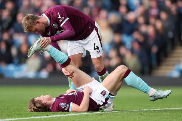 Joe Worrall helps Zian Flemming deal with cramp during Burnley's game against Brentford (Photo by Matt McNulty/Getty Images)